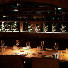 Ein Tisch, gedeckt mit eleganten Weingläsern und einer Flasche Wein, schafft eine raffinierte Atmosphäre beim Essen.